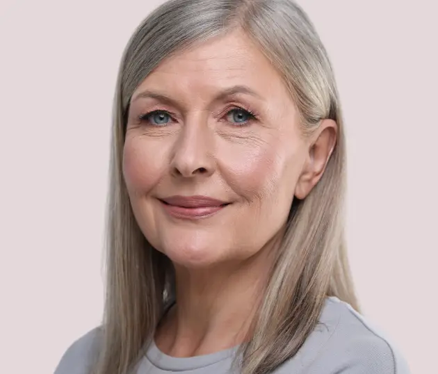 Portrait of a woman showing natural aging, including fine lines and mild skin laxity.