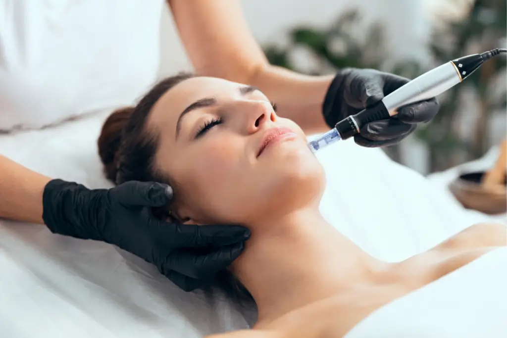 A provider uses a treatment device on a patient’s cheek.